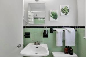 ein Badezimmer mit Waschbecken, Toilette und Spiegel in der Unterkunft Centrally Located Midtown Cottage-HistoricDistrict in Mobile + 66 Fotos