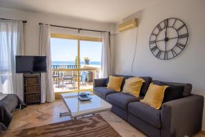 ein Wohnzimmer mit einem Sofa und einer Uhr an der Wand in der Unterkunft OleHolidays 655 Romana Playa vistas al mar in Marbella
