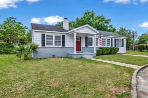 ein weißes Haus mit einer roten Tür in der Unterkunft Centrally Located Midtown Cottage-HistoricDistrict in Mobile