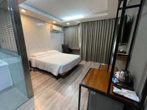 a hotel room with a bed and a table at Bangkok City Link Hotel in Bangkok
