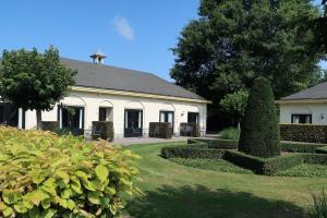 een groot wit huis met een tuin ervoor bij Kasteel De Vanenburg in Putten