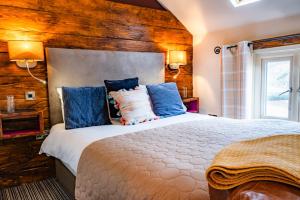 um quarto com uma cama grande e almofadas azuis em Harrys lounge em Whitby