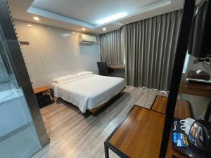 a bedroom with a bed and a desk and a table at Bangkok City Link Hotel in Bangkok