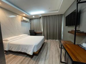 a hotel room with a bed and a television at Bangkok City Link Hotel in Bangkok