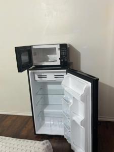 a microwave sitting on top of an open refrigerator at Bright Queen Room close to Sheridan College and Airport in Brampton
