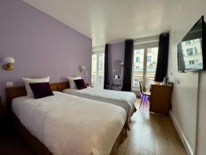 een hotelkamer met 2 bedden en een tafel bij Hôtel Du Leman in Parijs
