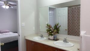 La salle de bains est pourvue de 2 lavabos et d'un grand miroir. dans l'établissement Bright Queen Room, à Brampton