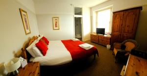 a bedroom with a bed with a red and white blanket at The Shrubbery Hotel in Shepton Mallet