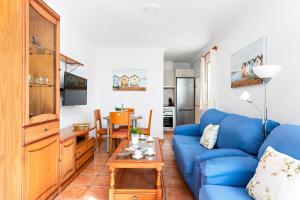 un soggiorno con divano blu e tavolo di Villa Sol Menorca a Punta Prima