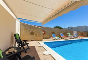 a villa with a swimming pool and lounge chairs at Villa Sol Menorca in Punta Prima