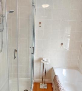 a bathroom with a shower and a tub and a sink at Storrbeck Guest House in Whitby