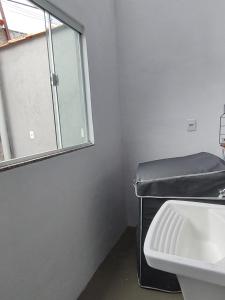 a bathroom with a sink and a window at Casa para Temporada in Resende