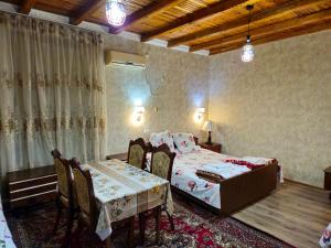 een slaapkamer met een bed en een tafel en stoelen bij B&B Bahodir in Samarkand