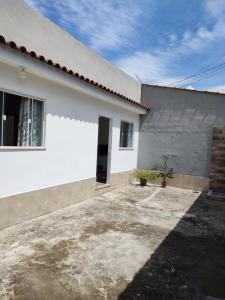 ein weißes Haus mit einem Fenster und einer Einfahrt in der Unterkunft Casa para Temporada in Resende