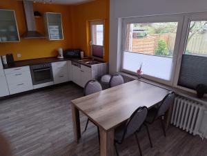 eine Küche und ein Esszimmer mit einem Holztisch und Stühlen in der Unterkunft LaPurka III Garten in Nordhorn