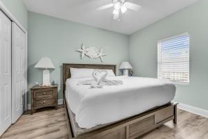 a bedroom with a large white bed with a ceiling fan at Laketown Wharf 1331 in Panama City Beach +26 photos