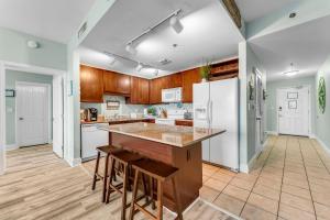 a kitchen with wooden cabinets and a white refrigerator at Laketown Wharf 1331 in Panama City Beach