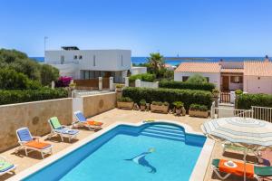 a swimming pool with a man in the middle of it at Villa Sol Menorca in Punta Prima