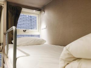 Rúm í herbergi á 日初青旅 Sundaily Hostel 北車