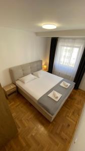 ein großes Bett in einem Zimmer mit Holzboden in der Unterkunft La Perla in Trebinje