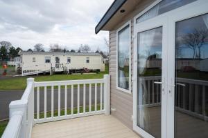 a screened porch with a view of a house at CALI - 3Bed - Static Caravan in Port Seton