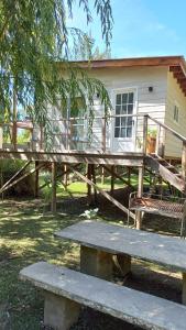 a picnic table and a bench in front of a house at La casita del Delta in Tigre