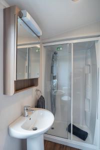 a bathroom with a white sink and a shower at CALI - 3Bed - Static Caravan in Port Seton