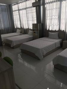 2 camas en una habitación con ventanas en KHÁCH SẠN NGUYỄN LONG en Ấp Tháp Mười