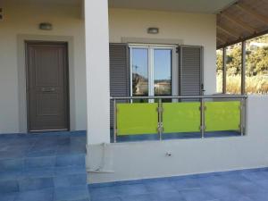 a balcony with a green fence and a door at Art Sailing in Vasiliki