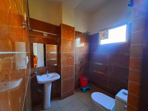 JIMS GATEWAY HOTEL AND RESTAURANT في رامناجار: حمام مع حوض ومرحاض