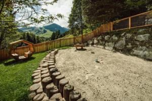 un patio trasero con una valla y un arenero y una valla en TheResi Appartements, en Saalbach Hinterglemm