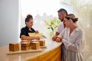 un grupo de personas de pie alrededor de un mostrador con comida en Occidental Nuevo Vallarta, en Nuevo Vallarta 