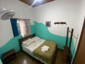 Un pequeño dormitorio con una cama con toallas. en Hospedaria São Jorge - Chapada dos Veadeiros en Sao Jorge