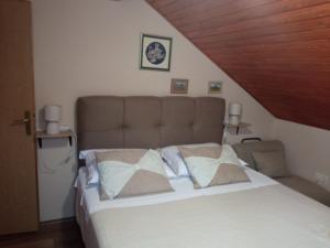 ein Bett mit zwei Kissen auf einem Zimmer in der Unterkunft Ruža in Skradin