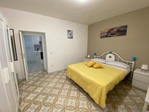 una camera da letto con un letto con una coperta gialla di Casa vacanza: The Wind Rose a Vietri