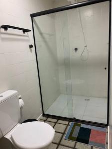 a bathroom with a toilet and a glass shower at Flat mobiliado na rua da Aurora in Recife