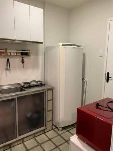 a kitchen with a refrigerator and a red appliance at Flat mobiliado na rua da Aurora in Recife