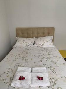 a bed with white towels and red shoes on it at Flat mobiliado na rua da Aurora in Recife