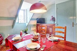 ein Esszimmer mit einem Tisch mit Tellern und Gläsern in der Unterkunft Appartement de 2 chambres a Juncalas in Juncalas