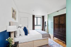 a bedroom with a bed and a table with a lamp at Hoxton Square - Urban Haven in London