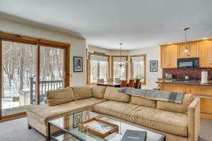 ein Wohnzimmer mit einem Sofa und einem Tisch in der Unterkunft Ski-In Resort Family Condo with Deck at Jay Peak! in Jay