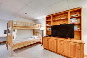 a bedroom with a bunk bed and a flat screen tv at Ski-In Resort Family Condo with Deck at Jay Peak! in Jay