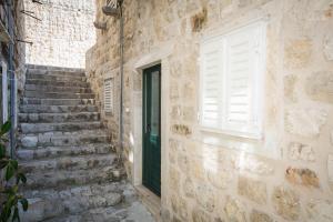 a stone building with a door and a window at Studio Sunny Garden in Dubrovnik