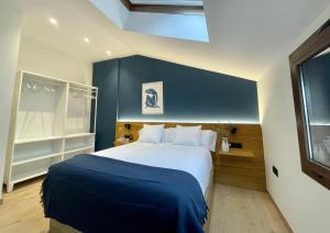 a bedroom with a large bed with a blue wall at Villa Gratal in Igriés