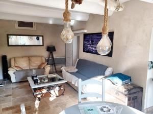 uma sala de estar com um sofá e uma mesa em Appartement de 3 chambres avec hammam jardin clos et wifi a Aix en Provence em Aix-en-Provence