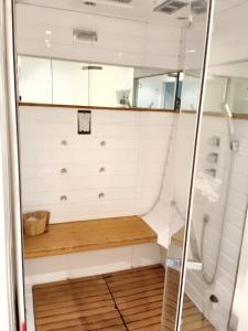 uma pequena casa de banho com um chuveiro e um banco em Appartement de 3 chambres avec hammam jardin clos et wifi a Aix en Provence em Aix-en-Provence