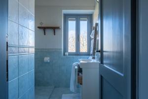 a blue bathroom with a sink and a window at Il Querceto by Great Stays in Città della Pieve +42 photos