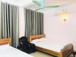 sypialnia z 2 łóżkami i wentylatorem sufitowym w obiekcie Khách sạn Hoa Biển A w mieście Xóm Côn