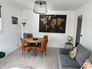 een woonkamer met een tafel en stoelen en een bank bij L’Etape berrichonne in Déols