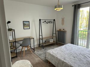 um quarto com uma cama, uma secretária e uma janela em L’Etape berrichonne em Déols
